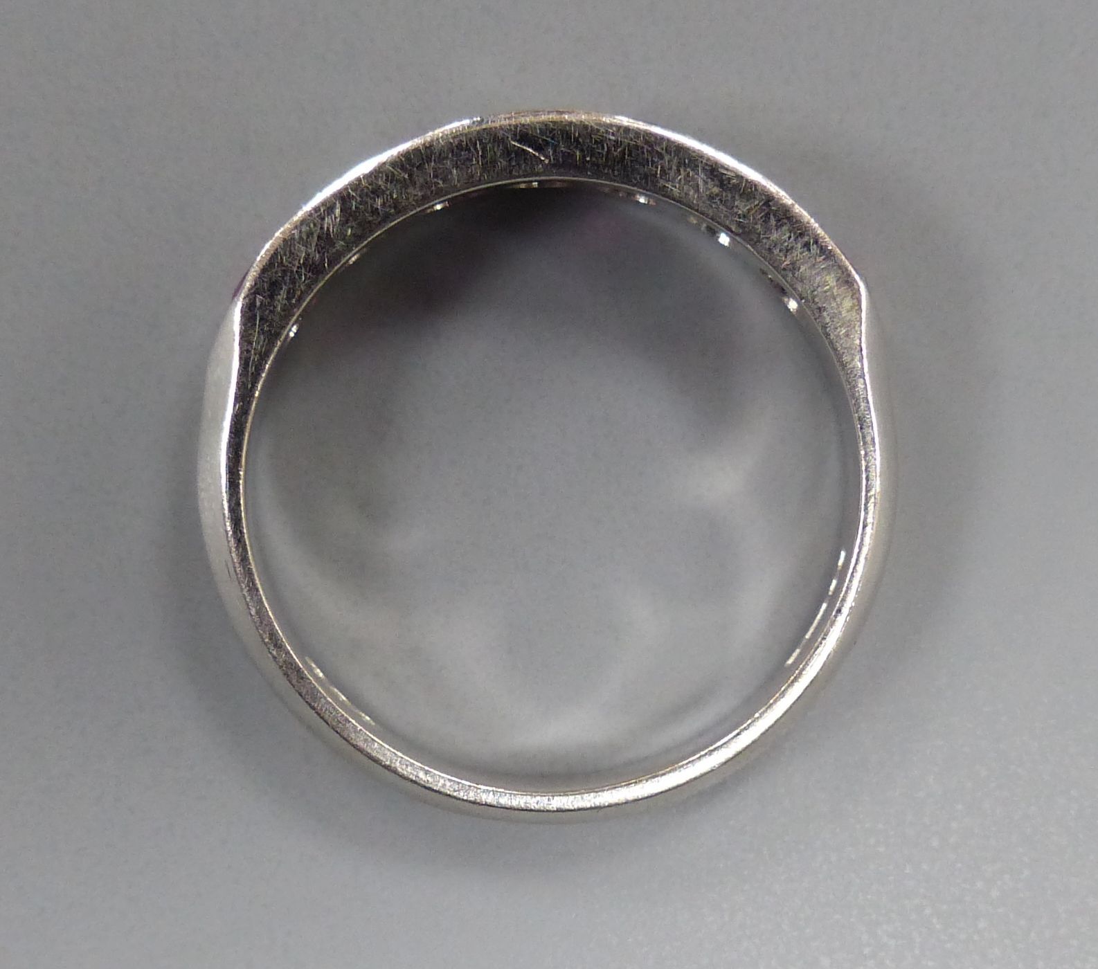 A modern 18ct white gold, four stone ruby and three stone diamond set half hoop ring, size M, gross 3.7 grams.